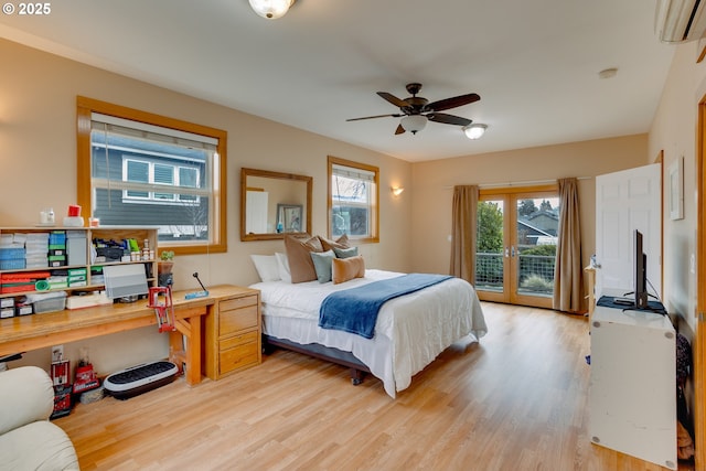 bedroom with light hardwood / wood-style flooring, access to outside, and a wall unit AC