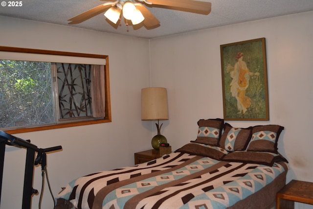 bedroom with ceiling fan and a textured ceiling