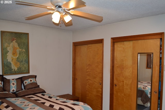 bedroom featuring multiple closets, ceiling fan, and a textured ceiling