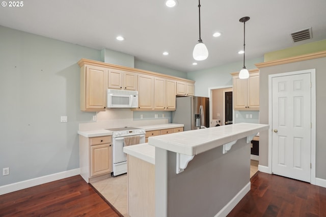 1705 SE 111th Ct, Vancouver, WA 98664 - kitchen featuring a center island, a kitchen breakfast bar, baseboards, white appliances, and tile counters