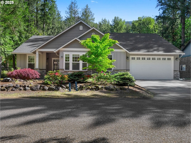 64911 E Mountain Meadow Ln, Rhododendron, OR 97049 - view of front of home featuring stone siding, board and batten siding, driveway, an attached garage, and roof with shingles