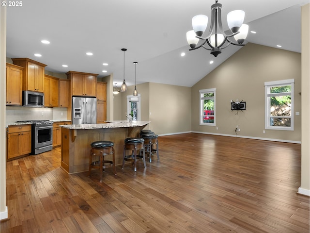 64911 E Mountain Meadow Ln, Rhododendron, OR 97049 - kitchen featuring stainless steel appliances, open floor plan, wood finished floors, a chandelier, and an island with sink