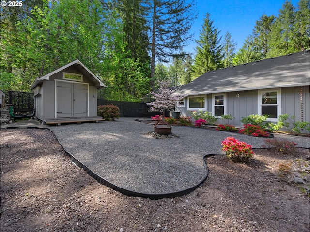 64911 E Mountain Meadow Ln, Rhododendron, OR 97049 - view of yard with a shed, a fire pit, an outdoor structure, fence, and central AC