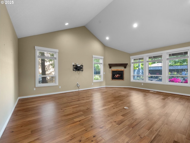 64911 E Mountain Meadow Ln, Rhododendron, OR 97049 - unfurnished living room with wood finished floors, high vaulted ceiling, a glass covered fireplace, baseboards, and recessed lighting