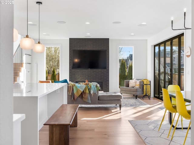 living room with light hardwood / wood-style floors and a brick fireplace