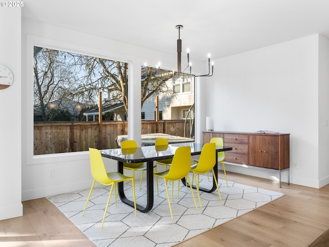 dining space with a notable chandelier and light hardwood / wood-style flooring