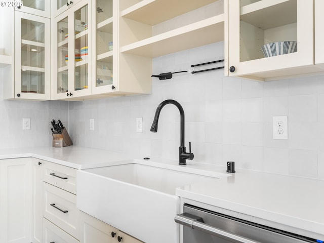 kitchen with white cabinetry, dishwasher, sink, and backsplash