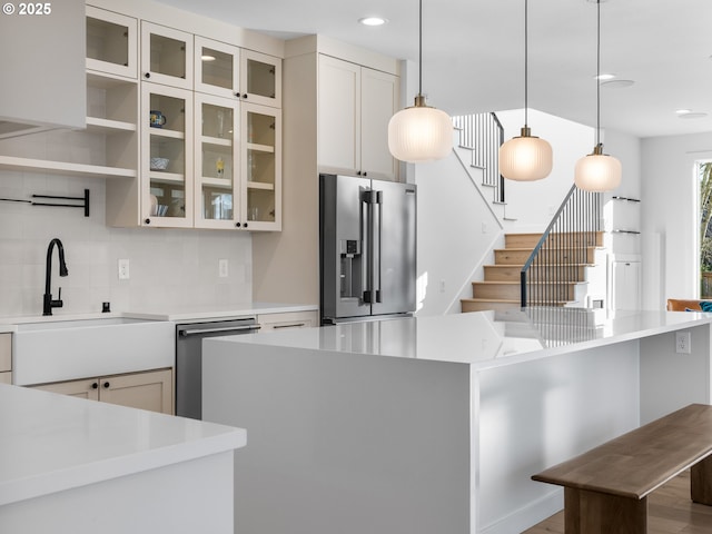 kitchen featuring sink, tasteful backsplash, decorative light fixtures, stainless steel appliances, and a large island