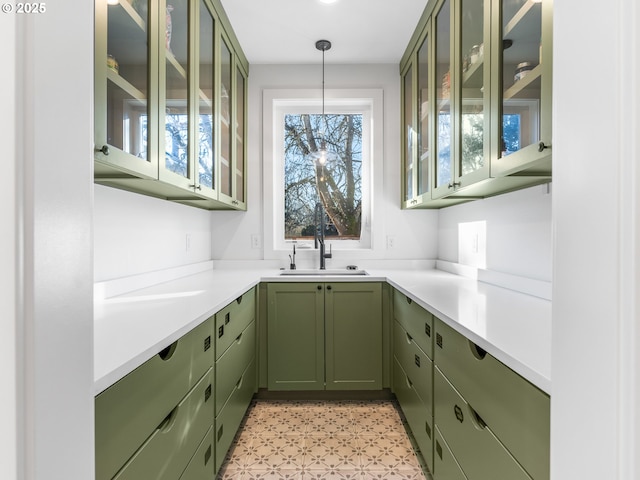 kitchen with hanging light fixtures, sink, and green cabinets