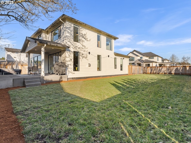 rear view of property with a lawn and a patio area