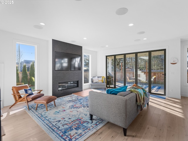 living room featuring a large fireplace and light wood-type flooring