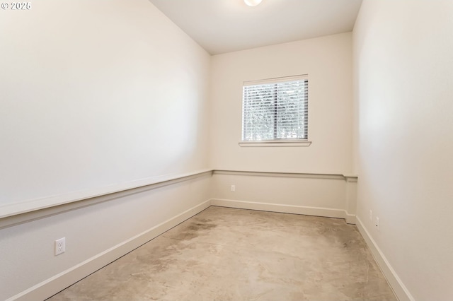 spare room with unfinished concrete floors and baseboards