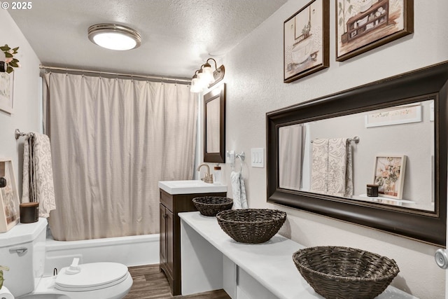 full bathroom with vanity, a textured ceiling, hardwood / wood-style flooring, shower / bathtub combination with curtain, and toilet