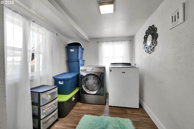 washroom featuring dark hardwood / wood-style flooring, washing machine and dryer, and a textured ceiling