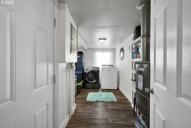 washroom with separate washer and dryer, dark wood-type flooring, and a textured ceiling