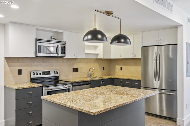 668 Mcvey Ave Unit 83, Lake Oswego, OR 97034 - kitchen with appliances with stainless steel finishes, light wood-style floors, a kitchen island, decorative light fixtures, and white cabinetry