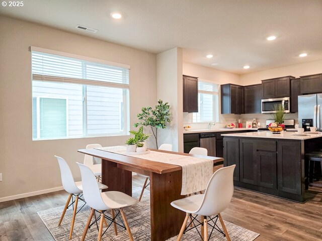 16156 NW Pristine Ln, Portland, OR 97229 - kitchen featuring appliances with stainless steel finishes, light countertops, light wood-style flooring, dark brown cabinetry, and recessed lighting