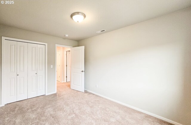 16156 NW Pristine Ln, Portland, OR 97229 - unfurnished bedroom with light carpet, baseboards, and a closet