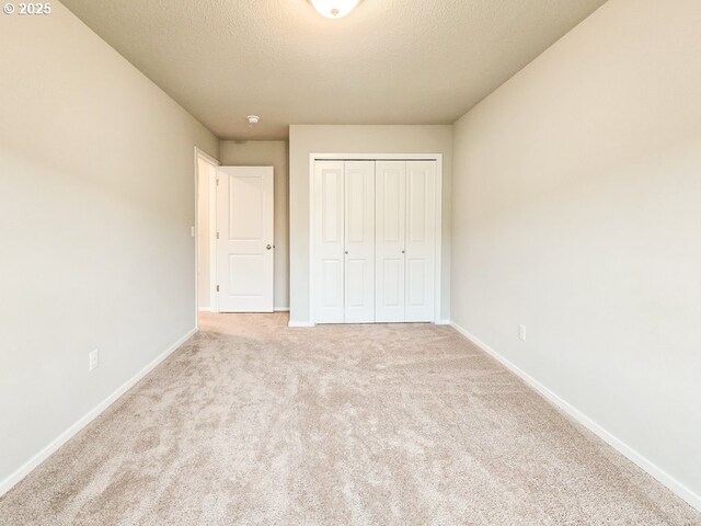 16156 NW Pristine Ln, Portland, OR 97229 - unfurnished bedroom with baseboards, carpet floors, a closet, and a textured ceiling