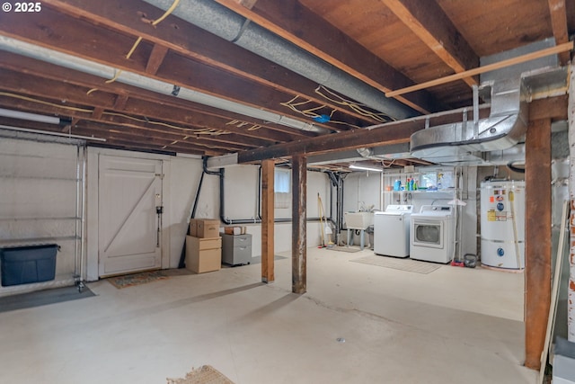 basement featuring a sink, strapped water heater, and washer and dryer