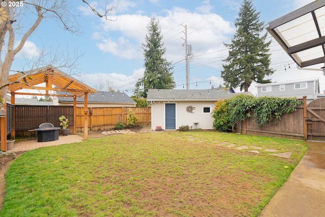 view of yard featuring a fenced backyard, a gate, and an outdoor structure