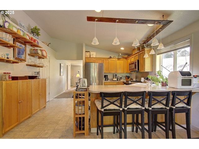 kitchen with decorative light fixtures, appliances with stainless steel finishes, vaulted ceiling, light countertops, and a peninsula