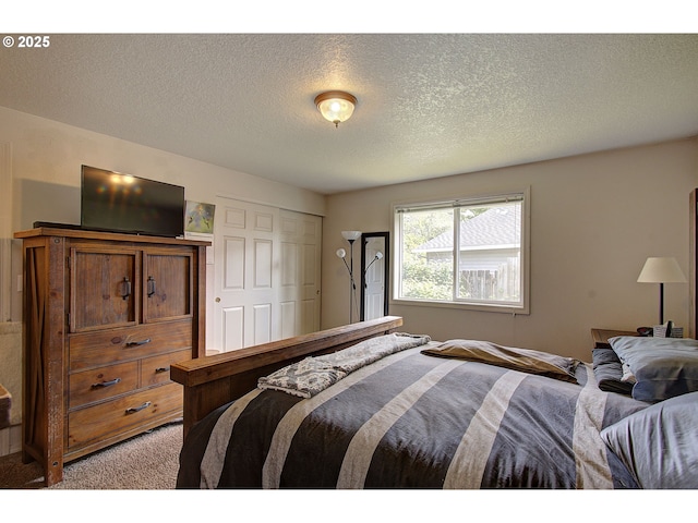bedroom featuring light colored carpet, a textured ceiling, and a closet