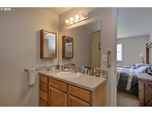 bathroom with connected bathroom, a textured ceiling, and vanity