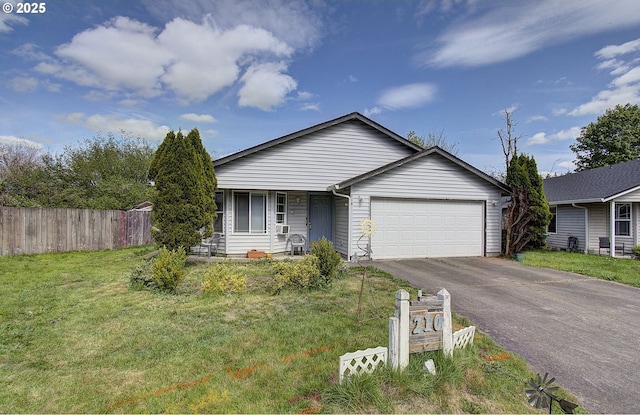 view of front facade with fence, an attached garage, driveway, and a front lawn