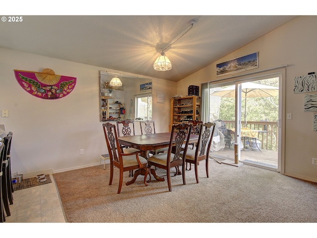 dining area featuring baseboards, carpet, vaulted ceiling, and a wealth of natural light