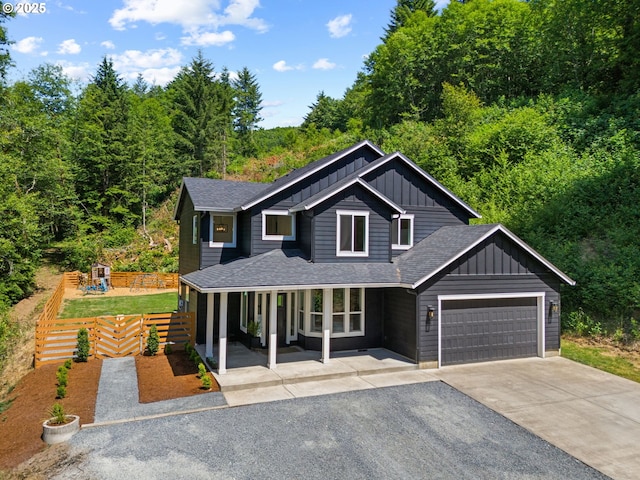 28009 NE Thompson Cir, Yacolt, WA 98675 - view of front of property featuring board and batten siding, asphalt driveway, an attached garage, covered porch, and roof with shingles