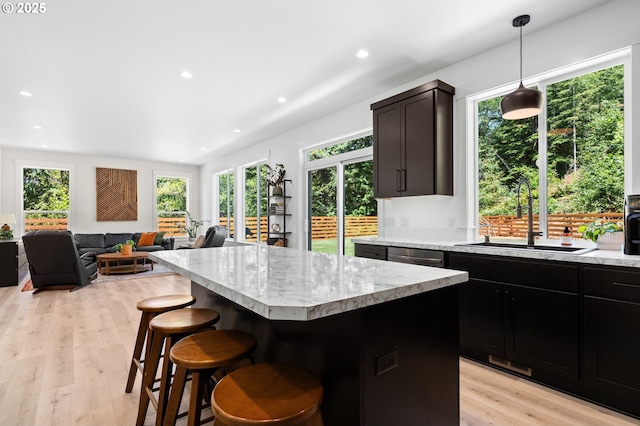 28009 NE Thompson Cir, Yacolt, WA 98675 - kitchen featuring a kitchen island, plenty of natural light, light wood-style flooring, a kitchen bar, and recessed lighting