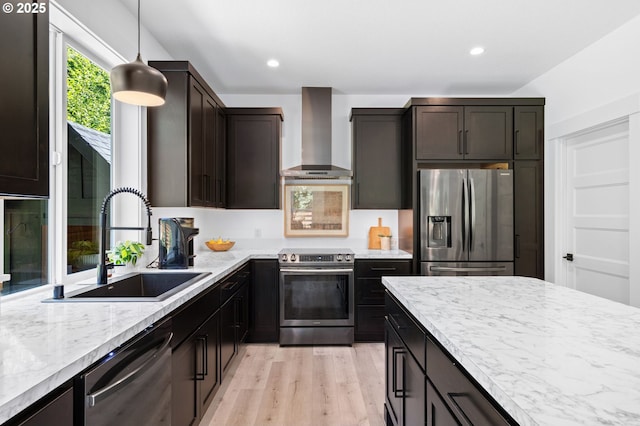 28009 NE Thompson Cir, Yacolt, WA 98675 - kitchen featuring stainless steel appliances, wall chimney exhaust hood, light wood-style floors, hanging light fixtures, and recessed lighting
