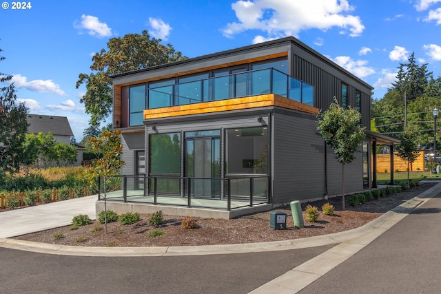 exterior space featuring concrete driveway and a balcony