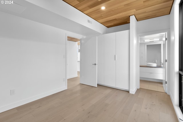 unfurnished bedroom featuring visible vents, connected bathroom, baseboards, light wood-type flooring, and wooden ceiling