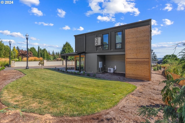 rear view of property featuring ac unit, a yard, and fence