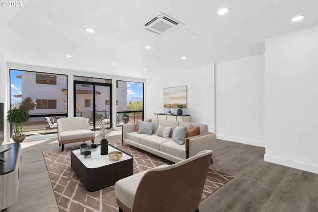 living room with visible vents, wood finished floors, recessed lighting, a wall of windows, and baseboards