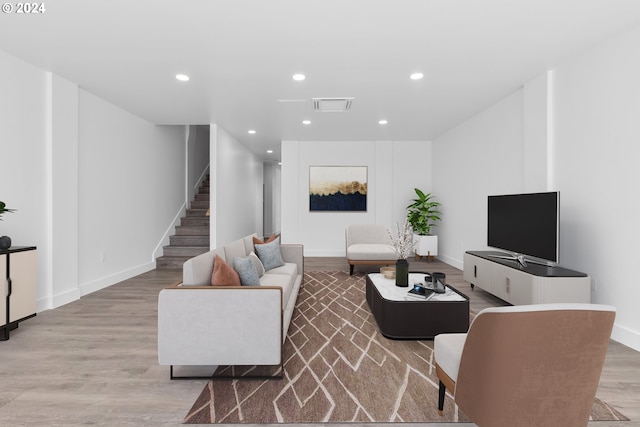 living area with light wood finished floors, visible vents, recessed lighting, and stairs