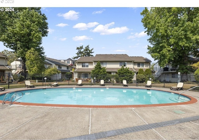 pool with fence and a residential view