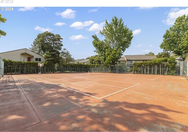 view of tennis court with community basketball court and fence