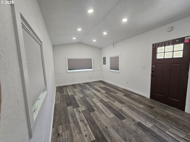 710 E Quince Ave, Hermiston, OR 97838 - unfurnished living room with a wall mounted air conditioner, dark wood finished floors, vaulted ceiling, recessed lighting, and baseboards