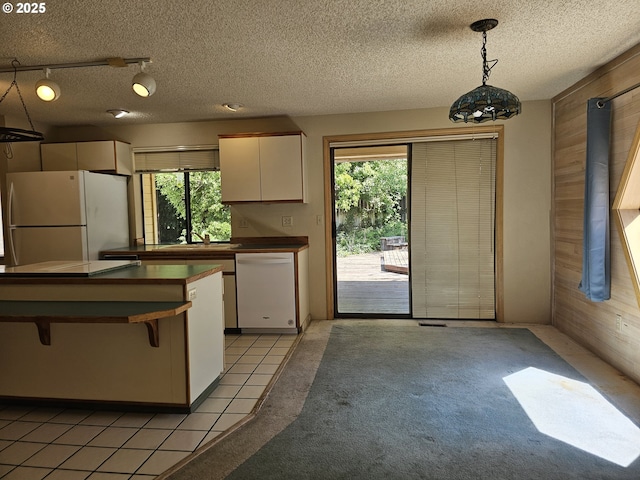 710 E Quince Ave, Hermiston, OR 97838 - kitchen featuring track lighting, freestanding refrigerator, white cabinets, a breakfast bar area, and a textured ceiling