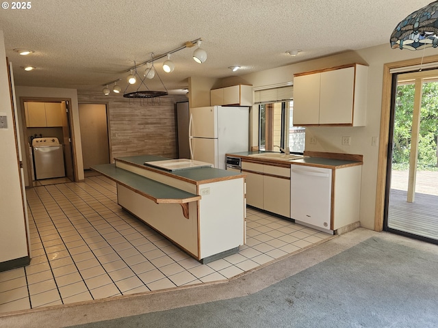 710 E Quince Ave, Hermiston, OR 97838 - kitchen featuring white appliances, healthy amount of natural light, a sink, wood walls, and hanging light fixtures