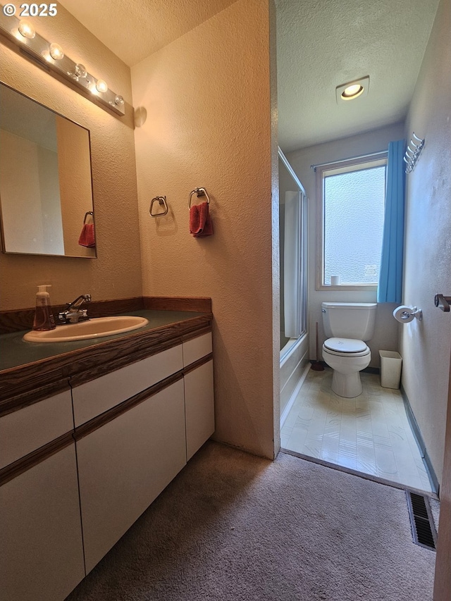 full bathroom featuring a textured ceiling, toilet, a textured wall, vanity, and tub / shower combination