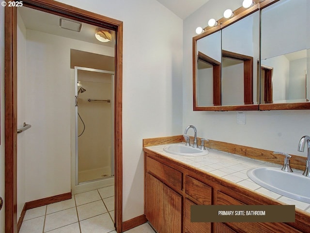 bathroom featuring tile patterned floors, a shower with shower door, and vanity