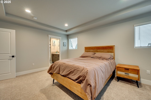 bedroom featuring light carpet, recessed lighting, baseboards, and a tray ceiling