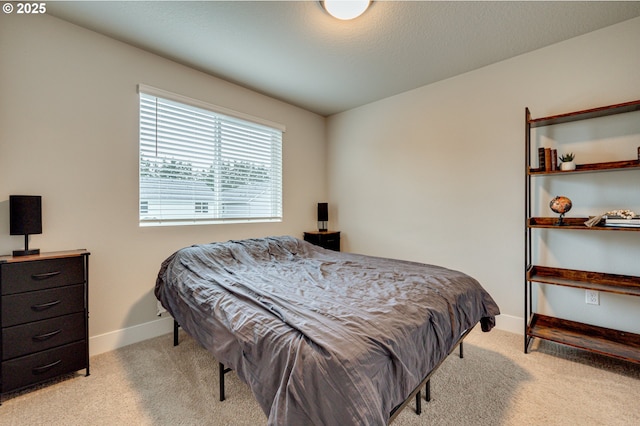 bedroom featuring baseboards and light carpet