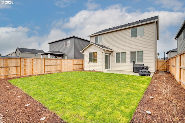 rear view of house with a patio area, a yard, and a fenced backyard