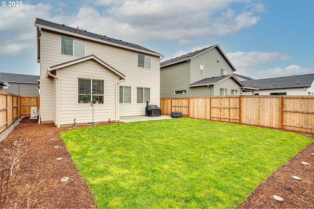 rear view of property with a yard, a fenced backyard, and a patio