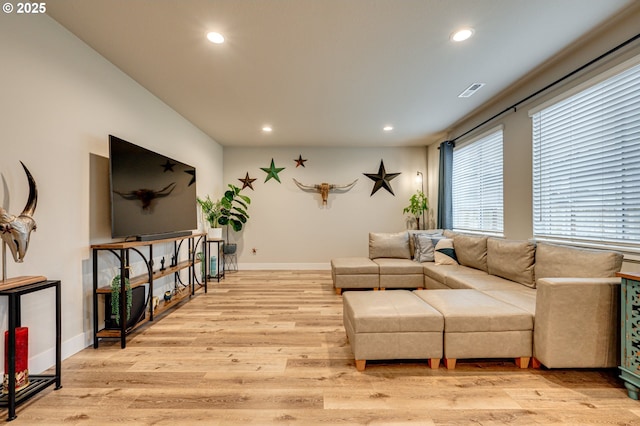 living room with recessed lighting, baseboards, and light wood finished floors